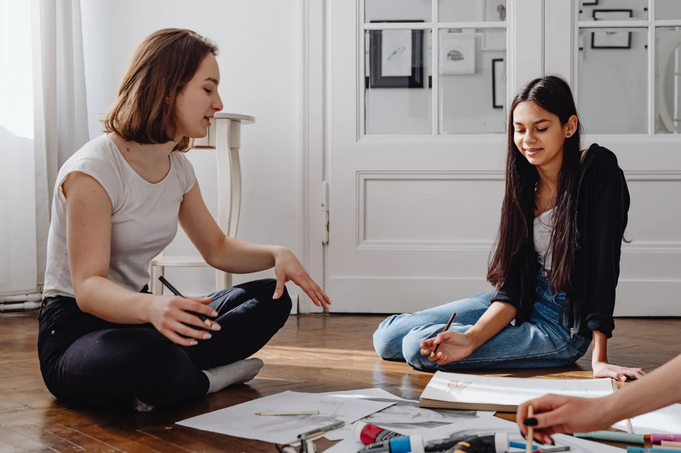 Young person engaged in a relaxed creative activity with supportive company